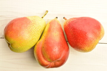 Sweet juicy pears, close-up, on a white wooden table.