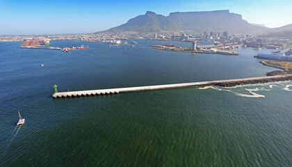 Cape Town, Western Cape / South Africa - 11/26/2019: Yacht rounds the beakwater at Table Bay Harbour with Table Mountain in the background