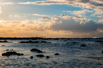 People are fishing at sunset. Beautiful sky on the background.
