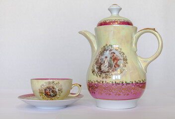 Porcelain teapot and cup on a white background.