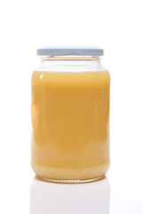Glass jar with ghee butter over white background. Nutrition concept - Healthy food, Diet, Detox, Clean Eating or Vegetarian concept.
