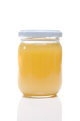 Glass jar with ghee butter over white background. Nutrition concept - Healthy food, Diet, Detox, Clean Eating or Vegetarian concept.
