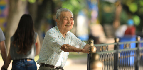 old man smiles and rests outdoors in summer