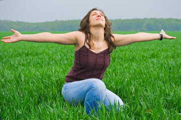 Portrait of a beautiful woman in a wheat field; woman enjoying the nature