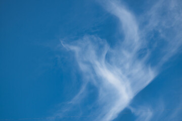Bright blue sky background with cirrus clouds