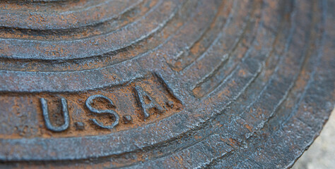 An old New Orleans manhole cover with colorful orange rust and aqua patina found in an industrial dump.