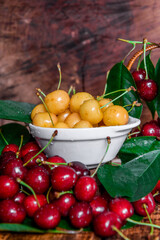 Red and yellow cherries with drops of water. Juicy berries. Close-up.