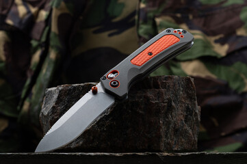 Knife for emergency situations on a stone. Military uniform and knife.