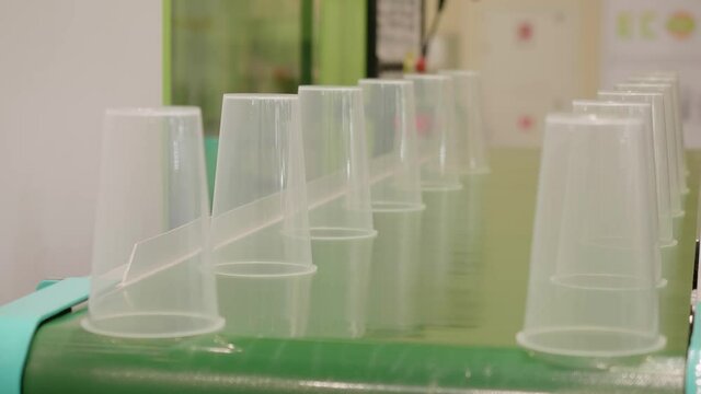 Disposable plastic cup are on conveyor.