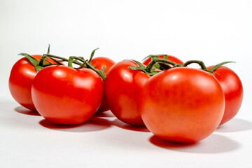 a sprig of red tomatoes is isolated on a white background