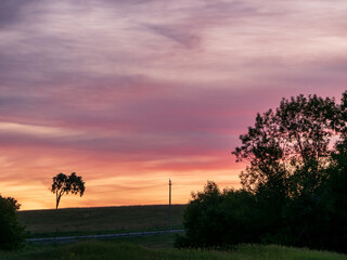 Fototapeta na wymiar pink and orange sunset near road