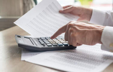 Hands of businessman doing finances and calculate on desk about cost. Concept finances and economy....