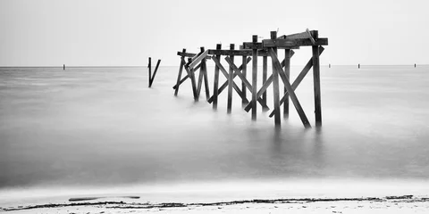 Papier Peint photo Noir et blanc Une longue exposition image minimaliste en noir et blanc d& 39 une vieille jetée délabrée debout dans les eaux peu profondes du golfe du Mexique