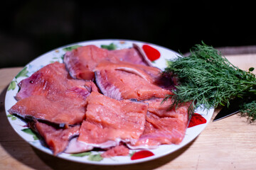 pieces of red fish fillet on a plate with greens.