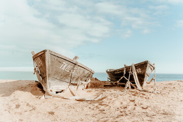 too old wooden boats on a sandy beach