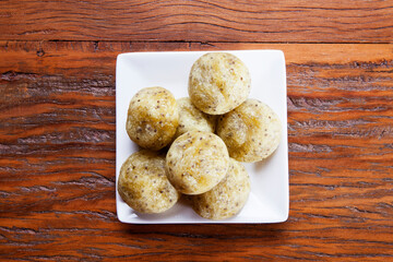 Healthy homemade cheese buns with chia, rustic style, on a white plate over wooden background.