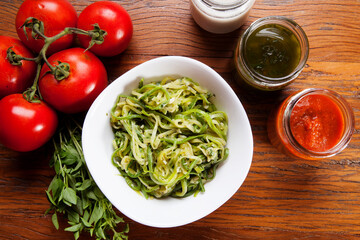 Nutrition concept - Healthy food, Diet, Detox, Clean Eating or Vegetarian concept. Healthy pasta with sauce, basil, fresh tomatoes over rustic wooden background
