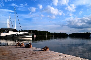 Pomost z widokiem na jezioro i jacht na Mazurach w Polsce © Joanna