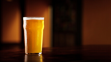 Pab style. Misted glass with drops with light beer on wooden table in dark bar interior