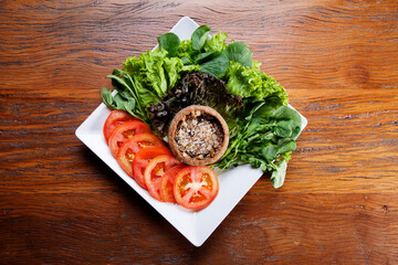 Nutrition concept - Healthy food, Diet, Detox, Clean Eating or Vegetarian concept. A delicious quiche with salads and tomatoes slices in white plate over wooden background.