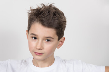 Teenage boy in white shirt. Portrait in studio. Funny faces.