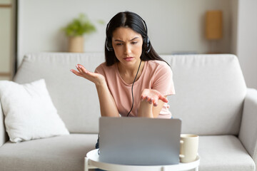 Displeased Woman Making Video Call Using Laptop Sitting At Home