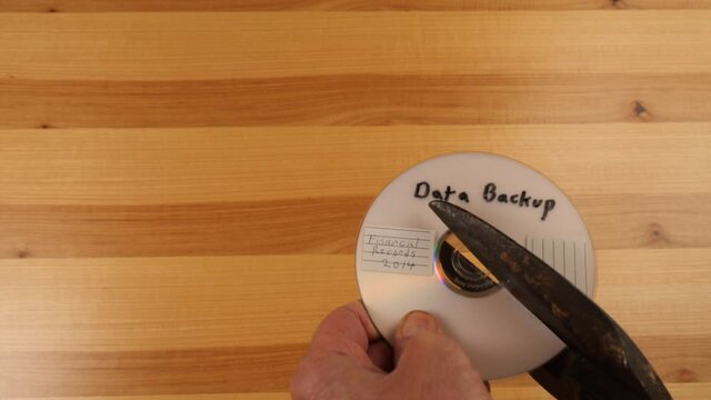 Cutting up an old optical data disk before throwing it away