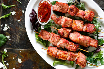Pork skewers with sauce and herbs on a wooden skewer