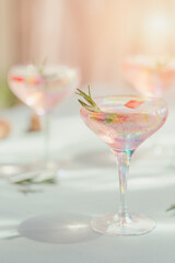 Glass of strawberry cocktail or mocktail, refreshing summer drink with crushed ice and sparkling water on light blue background.