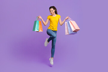 Seasonal Sales. Happy Young Asian Girl Jumping In Air With Shopping Bags