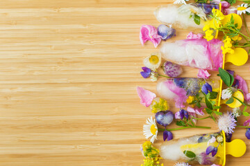 Floral Ice Pops and fresh summer flowers with space for text. Colorful wildflowers in melting ice...