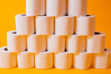 Toilet paper rolls as a wall background pattern over yellow