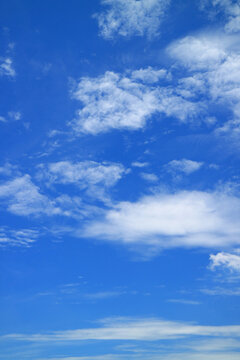 Vertical image of vivid blue sky with pure white clouds