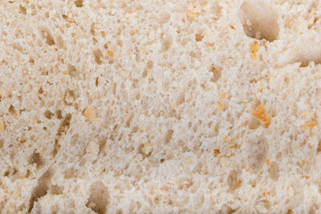 Slice of white Bread skin surface texture pattern close up detail macro. Abstract background.