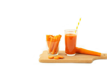 Glass of carrot juice and fresh carrot on cutting board