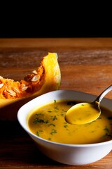 Nutrition concept - Healthy food, Diet, Detox, Clean Eating or Vegetarian concept. Healthy Pumpkin soup puree with fresh pumpkins pieces on an old wooden table.