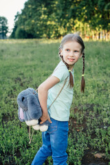 A girl of European appearance with two pigtails and a backpack looks away 