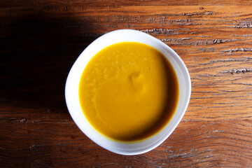 Nutrition concept - Healthy food, Diet, Detox, Clean Eating or Vegetarian concept. Healthy Pumpkin soup puree with fresh pumpkins pieces on an old wooden table.