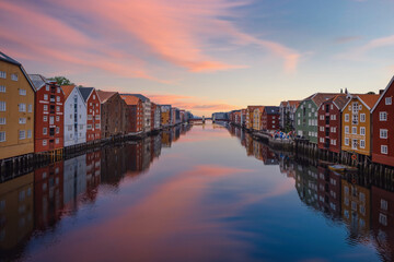 TRONDHEIM, NORWAY, july 2019: Sunrise view of colorful timber houses surrounding river Nidelva in the Brygge district of Trondheim, Norway