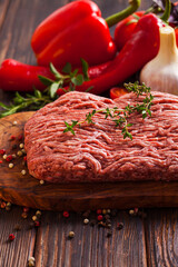 The fresh minced meat and vegetables on the wooden table