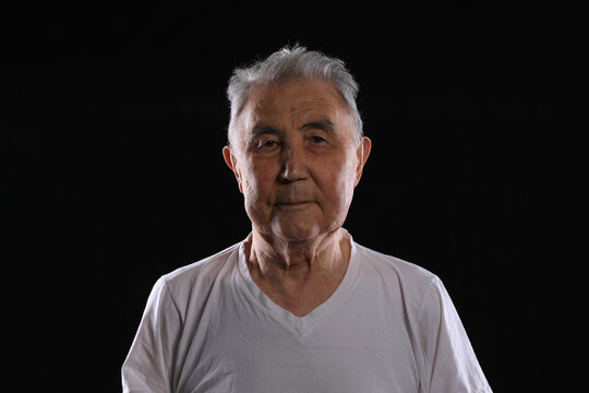studio portrait of an old man on a black background
