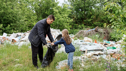 Naklejka na ściany i meble a middle-aged man, a father and his daughter are putting garbage in a black bag