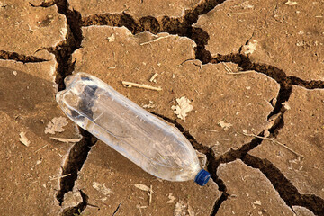 A bottle of water on the dried ground. 
The concept of thirst, dehydration.
