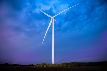 Fototapeta premium Wind farm windmill at dusk with dramatic background.