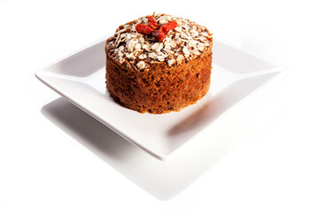 Fruit cake over white background. Traditional homemade Christmas cake with goji berries and Damascus flower decorations. White background.