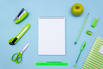 Empty sheet of notebook and school stationery on a blue background. Layout, place for text.