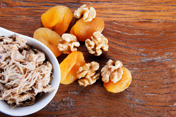 Nutrition concept - Healthy meals made of chicken, nuts and Damascus in bowls over wooden...