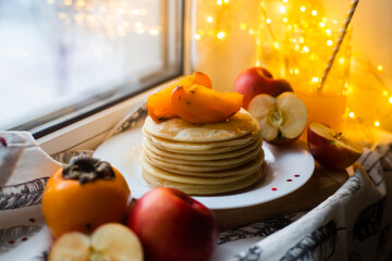 pancakes with fruit on a windowsill in winter