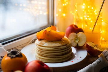 pancakes with fruit on a windowsill in winter