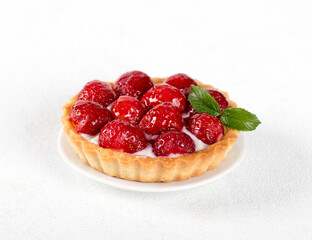 Tartlet with custard and strawberries on a white background